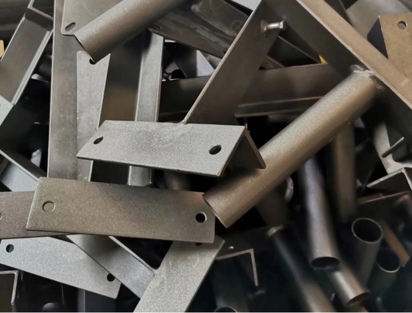 A close-up of a pile of black-painted metal parts